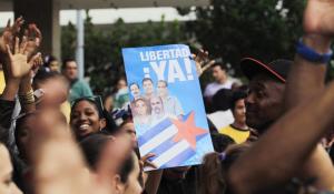 People cheer for the "Cuban Five" while holding a poster of the five Cuban intelligent agents, in Havana December 17, 2014. After 18 months of secret talks facilitated by the Vatican and Canada, Obama and Cuban President Raul Castro agreed by phone on Tuesday on a prisoner exchange and the opening of embassies in each other's countries. Obama said the moves were made possible by Havana's release of American Alan Gross, 65, who had been imprisoned in Cuba for five years. Cuba is also releasing an intelligence agent who spied for the United States and was held for nearly 20 years, and the United States in return freed three Cuban intelligence agents held in the United States. The poster reads "Freedom now !". REUTERS